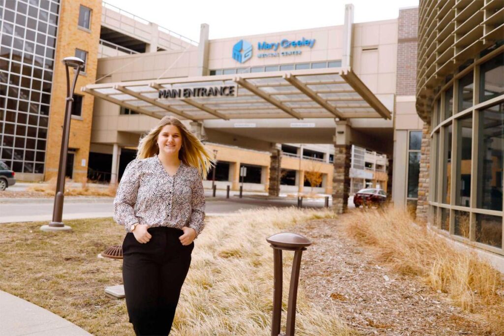 Chloe Jaeger in front of Mary Greeley Medical Center